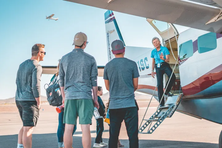 group of people standing outside airplane